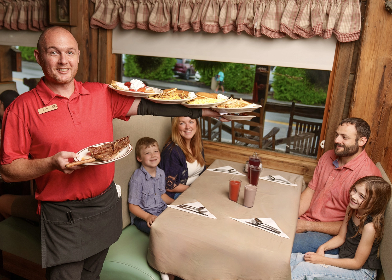 server with plates at a family's table at Log Cabin Pancake House